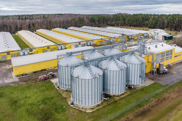 Fototapeta na wymiar aerial panoramic view over silos and agro-industrial livestock complex on agro-processing and manufacturing plant with modern granary elevator. chicken farm. rows of chicken coop