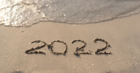 The numbers 2022 are washed away by the sea waves of the Persian Gulf. The concept of a change of years