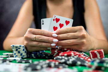 woman sitting on table playing poker holding cards proudly celebrating success very excited.