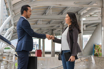 Businessman and businesswoman hands shaking after joined partner contract