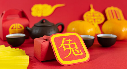 Chinese New Year 2023 festival decorations, mandarins, tea, envelopes on red background.