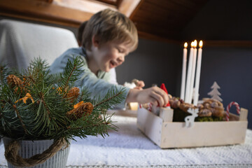 A boy play with Christmas toys on the table