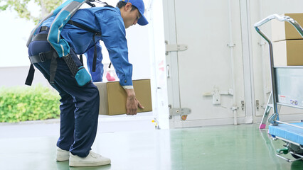 倉庫でパワーアシストスーツを使う作業員