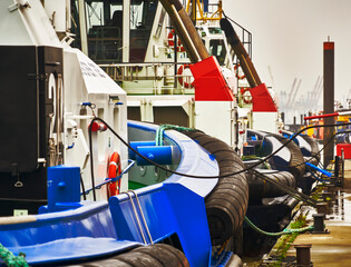 Tugboats lined up on the pier of the harbor basin, waiting for their next assignment to guide large ocean-going vessels