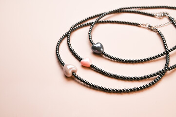 Set of round necklaces from beads on pastel pink background