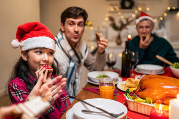Multi-ethnic big family celebrating Christmas party together in house. 