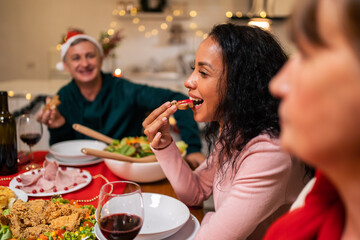 Multi-ethnic big family celebrating Christmas party together in house. 