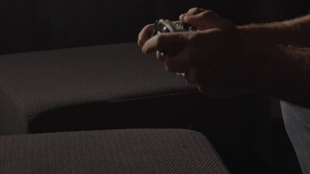 Male hands frantically playing on videogame controller and putting it down when the game is over