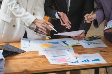 Marketing, Finance, Accounting, Planning, A team of businessmen plan with their laptops and graph charts for their profits and use a calculator to calculate their company is annual balance.