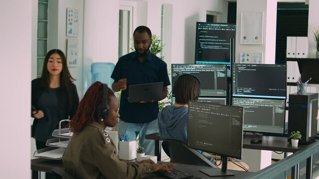 African american focused software engineer working on computer screen and typing in it office. Database programer writing code with algorithms, using new server interface on terminal window.