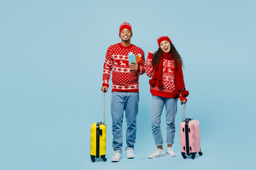 Traveler merry couple two man woman wear red Christmas sweater hat holding valise passport ticket...