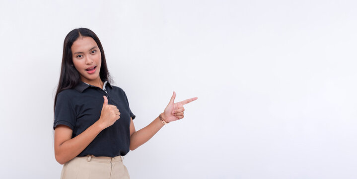 A young female employee points to the right while making a thumbs up sign. A competent person vouching for a service.