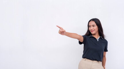 A pretty and young asian woman wearing a black polo shirt points to the left with her finger. Endorsing a product or service. Isolated on a white background.