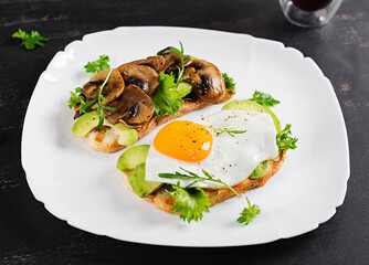 Sandwiches  with avocado, fried egg and mushrooms  for healthy breakfast or snack.