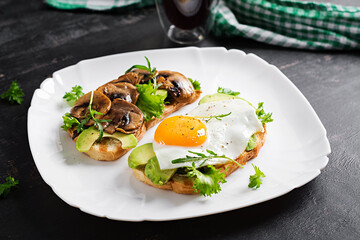 Sandwiches  with avocado, fried egg and mushrooms  for healthy breakfast or snack.