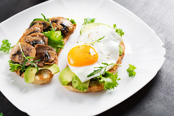 Sandwiches  with avocado, fried egg and mushrooms  for healthy breakfast or snack.
