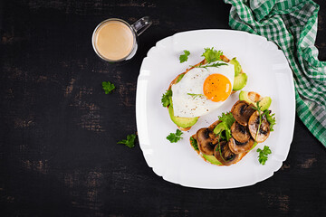 Sandwiches  with avocado, fried egg and mushrooms  for healthy breakfast or snack. Top view, above