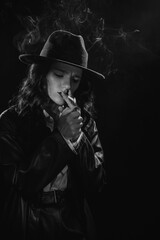 Fototapeta na wymiar Dark noir portrait of a female detective lighting a cigarette. Private detective, spy, investigation concept.