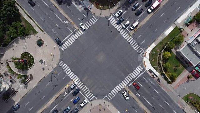 Public transit buses, pedestrians, bikes and vehicles at busy city intersection