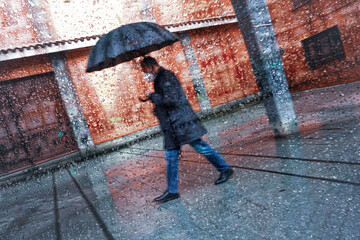 pedestrian with an umbrella in rainy days in Bilbao city, basque country, spain
