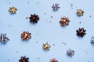 Abstract festive XMAS background with bows and beads top view. New Year Christmas background flat lay