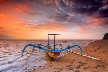 Traditional Balinese ships Jukung in Sanur beach at sunrise, Bali, Indonesia