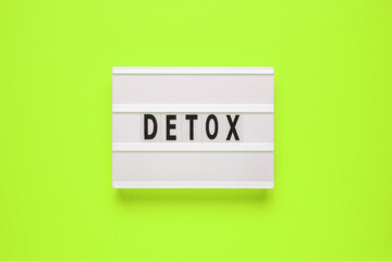 Lightbox with word detox on green background. Healthcare concept. Digital detox as disconnected internet life style concept.