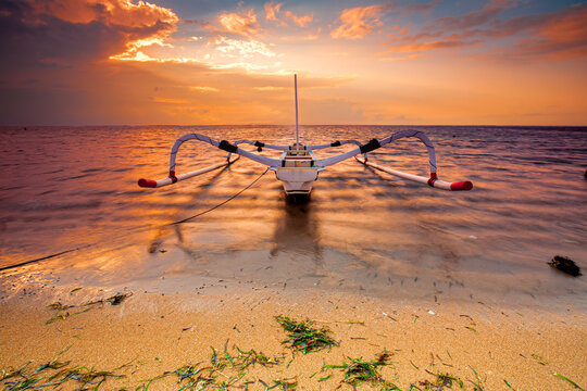 Traditional Balinese ships Jukung in Sanur beach at sunrise, Bali, Indonesia