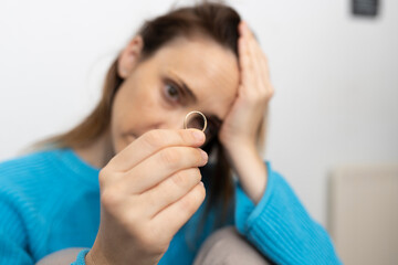 depressed woman looking at wedding ring. divorce concept