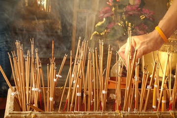 Hand lace incense on joss stick pot to make a wish,Incense that was lit to worship,Make merit for Temple Thailand