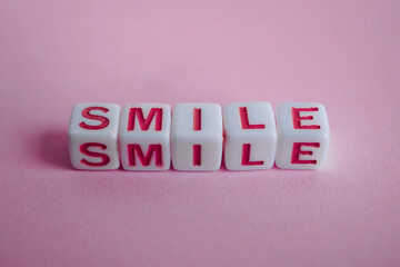 smile word on the pink background, feelings and emotions