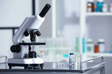 Modern medical microscope on metal table in laboratory, space for text