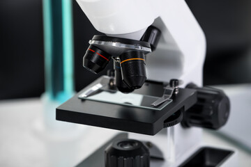 Modern microscope with glass slide in laboratory, closeup