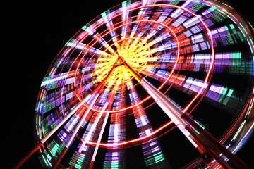 Beautiful glowing Ferris wheel against dark sky, low angle view