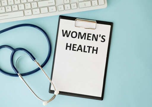 Stethoscope on note book with Women's Health words as medical concept