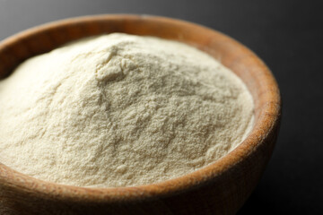 Bowl of agar-agar powder on black background, closeup