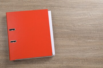 Red office folder on wooden table, top view. Space for text
