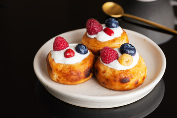 Breakfast cheese pancakes with blueberries, raspberries and sour cream.