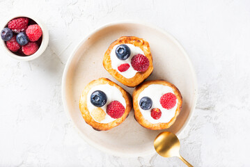 Traditional Ukrainian food cheese pancakes with blueberries, raspberries and sour cream.