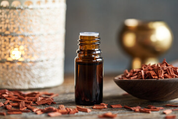 Pieces of red sandalwood with a brown bottle of essential oil