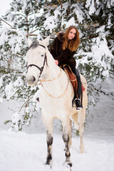 Winter coniferous forest with snow. Young girl with long hair on a horse. Christmas vacation