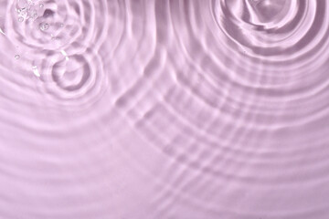 Closeup view of water with rippled surface on violet background