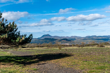 panorama sur la chaine des puy avec le volcan du puy de dôme dépassant tous les autre monts sur le chemin de randonnée du lac d'Aydat en Auvergne