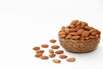 small grains of natural brown dried almonds in a decorative plate on a white background