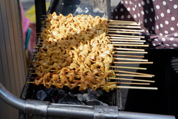 selective focus on chicken intestine satay and grilled meatballs skewered using bamboo and sold at culinary festivals. grilled over wood charcoal