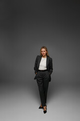 middle aged woman in office suit in studio with gray background