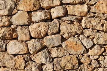 Wall made of rough clear brown stones. Perfect for textures and patterns