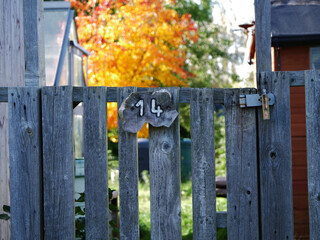 Number fourteen painted on rickety wooden fence 