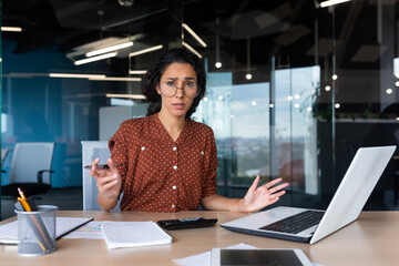 Frustrated and tired business woman looking at camera, Hispanic woman unhappy with work result,...
