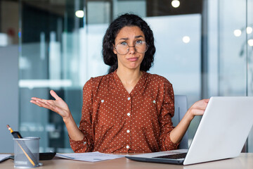 Frustrated and tired business woman looking at camera, Hispanic woman unhappy with work result,...